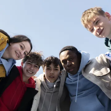 Photo d'un groupe d'adolescents dont deux filles et 3 garçons dehors