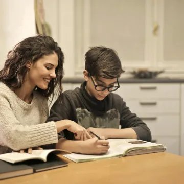 Photo d'une femme adulte qui aide un jeune à faire ses devoirs